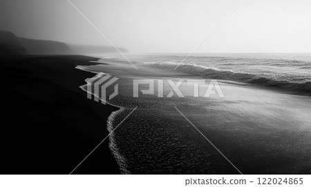 Black and white photo of a beach with a foggy sky in the background. The water is calm and the beach is empty Black and white photo of a beach with a foggy sky in the background. The water is calm and the beach is empty 122024865