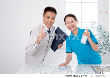 Senior housekeeper cleaning the kitchen Senior housekeeper cleaning the kitchen 122024926