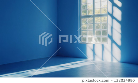 Window in a room with a blue wall. The window is letting in sunlight, creating a bright and airy atmosphere 122024990