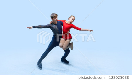 Professional ice skating partners perform difficult lift, show their elegance against cold blue background. Artistic ice dance. 122025088