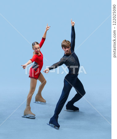 Figure skating pair displaying synchronized pose with poise and elegance against cold blue background, representing dedication and teamwork 122025090