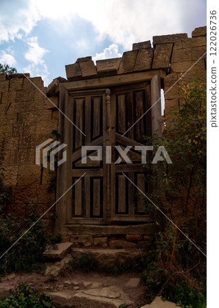 Dagestan Gamsutl. Ancient ghost town of Gamsutl old stone houses in abandoned Gamsutl mountain village in Dagestan, Abandoned etnic aul, summer landscape. Dagestan Gamsutl. Ancient ghost town of Gamsutl old stone houses in abandoned Gamsutl mountain village in Dagestan, Abandoned etnic aul, summer landscape. 122026736