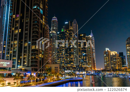 Night view on Dubai Marina skyscrapers, cruise boats and promenade in this luxury city, Dubai, United Arab Emirates. High quality photo Night view on Dubai Marina skyscrapers, cruise boats and promenade in this luxury city, Dubai, United Arab Emirates. High quality photo 122026874