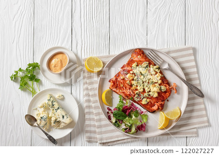 baked salmon topped with blue cheese on a plate 122027227