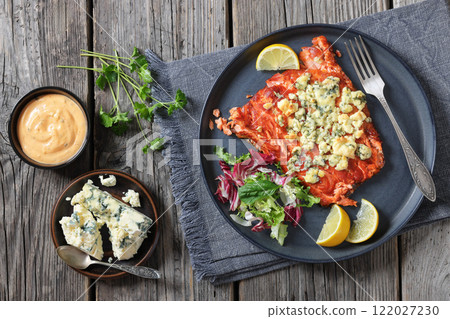 baked salmon topped with blue cheese on a plate 122027230