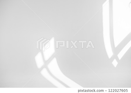 White background with shadow from two windows. Morning sunlight shines through the window, forming a shadow on the surface of the wall. 122027605