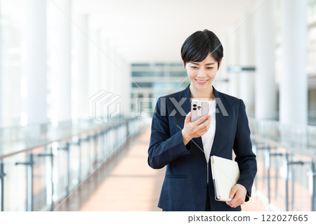 在辦公室使用智能手機的女商人 在辦公室使用智能手機的女商人 122027665