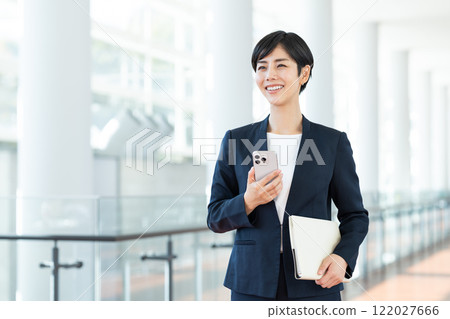 Business woman using a smartphone in the office Business woman using a smartphone in the office 122027666