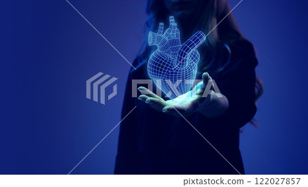 Female hand presenting a glowing digital heart hologram, representing medical innovation and cardiovascular research. Female hand presenting a glowing digital heart hologram, representing medical innovation and cardiovascular research. 122027857