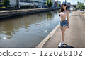 Young woman in shorts standing by the river 122028102