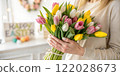A woman is gently holding a beautiful bouquet of flowers in her hands 122028673