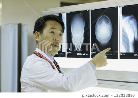 A doctor looking at an X-ray and explaining it. Photo courtesy of Tokyo Electronics College, Denpa Gakuen Corporation. A doctor looking at an X-ray and explaining it. Photo courtesy of Tokyo Electronics College, Denpa Gakuen Corporation. 122028886