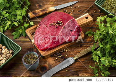 Raw red meat cuts on cutting board. 122029194