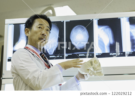 A doctor explaining an X-ray photo at a seminar. Filming cooperation: Tokyo Electronics College, Denpa Gakuen Corporation 122029212