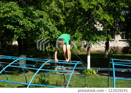 Boy practicing parkour on playground equipment. Boy practicing parkour on playground equipment. 122029241