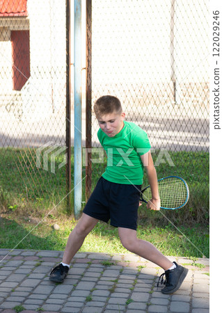 Young boy with tennis racket near court. Ready for a game. 122029246
