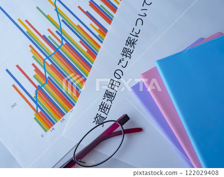 桌上放著圖表、眼鏡、文件和筆記本 122029408