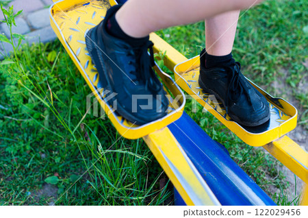 Feet on outdoor fitness equipment, enjoying a workout in the park. Feet on outdoor fitness equipment, enjoying a workout in the park. 122029456