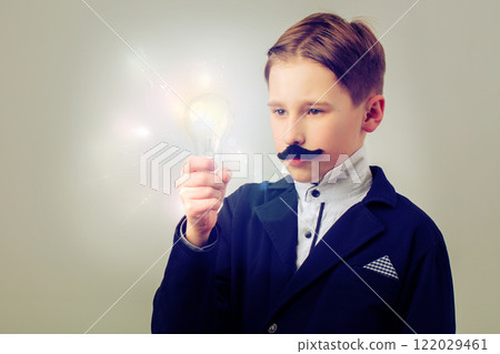 Portrait of a humorous vintage scientist. A child with a false mustache and a light bulb. Success, idea and education. Portrait of a humorous vintage scientist. A child with a false mustache and a light bulb. Success, idea and education. 122029461