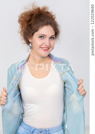 Vertical portrait of a happy young girl in a denim shirt. Vertical portrait of a happy young girl in a denim shirt. 122029680