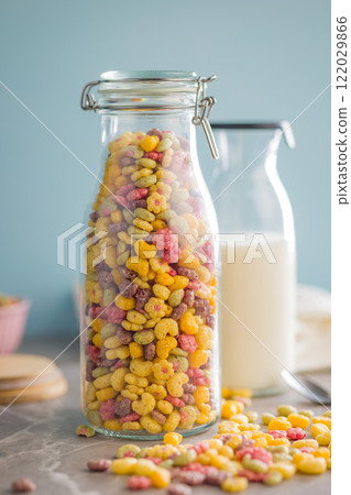 Colorful breakfast cereals in the shape of various fruit in jar on kitchen table. Colorful breakfast cereals in the shape of various fruit in jar on kitchen table. 122029866