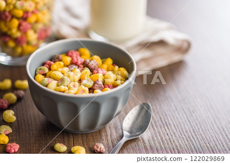 Colorful breakfast cereals in the shape of various fruit in bowl on wooden table. 122029869