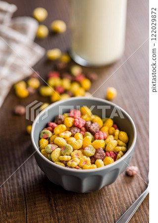 Colorful breakfast cereals in the shape of various fruit in bowl on wooden table. 122029872