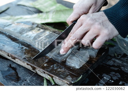 man cutting some pieces of aloe gel 122030062