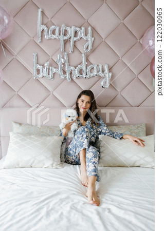 Woman celebrating birthday with her dog in bedroom 122030965