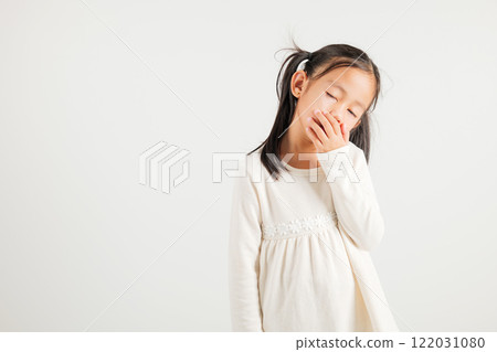 Portrait Asian young kid girl emotions tired and sleepy yawning covering mouth open by hand, studio shot isolated on white background, Thai kindergarten child insomnia concept with copy space Portrait Asian young kid girl emotions tired and sleepy yawning covering mouth open by hand, studio shot isolated on white background, Thai kindergarten child insomnia concept with copy space 122031080