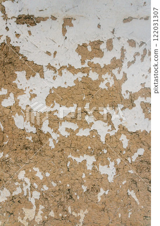 wall of house built with hay and clay. paint peeling off from wall. texture of clay and light paint 122031307