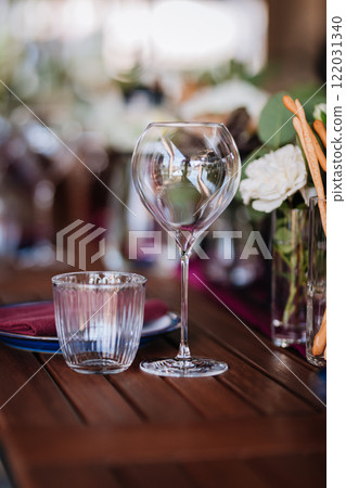 Elegant wine glass and water glass on a rustic table, perfect for fine dining and event settings Elegant wine glass and water glass on a rustic table, perfect for fine dining and event settings 122031340