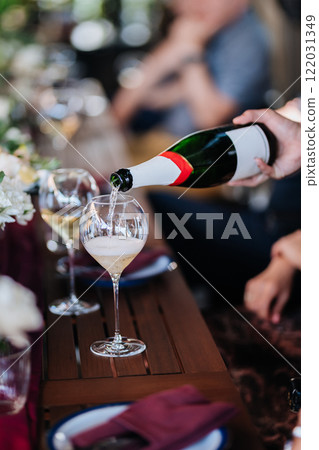 Pouring champagne into a glass at an elegant celebration, perfect for festive and special occasions 122031349