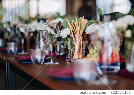 Luxurious dining table setup with flowers, appetizers, and wine glasses for an elegant celebration Luxurious dining table setup with flowers, appetizers, and wine glasses for an elegant celebration 122031361