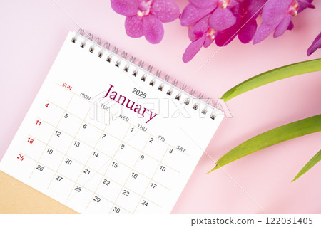 Desk calendar for January 2026 with blooming pink orchid. Flay lay. 122031405