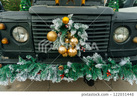 radiator grille of a car with a New Year's wreath. festive Christmas decorations in the car showroom 122031448