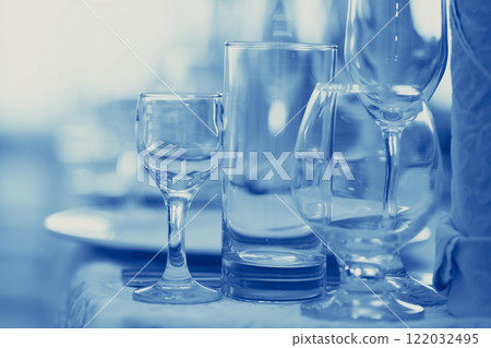 Glass goblets on the restaurant table tinted in blue. Glass goblets on the restaurant table tinted in blue. 122032495