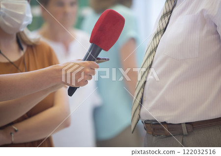 Interview. Hand with a microphone and an important gentleman in a tie. 122032516