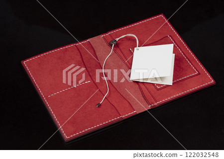 Open leather red purse with pockets on a dark background. 122032548