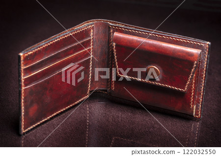 Leather open wallet in brown on a black background. 122032550