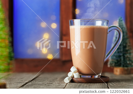 hot chocolate or cocoa with marshmallows in glass cup on table with window hot chocolate or cocoa with marshmallows in glass cup on table with window 122032661
