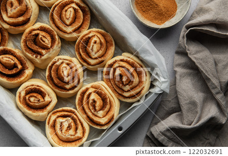 Delicious cinnamon rolls prepared for baking in a rectangular pan 122032691