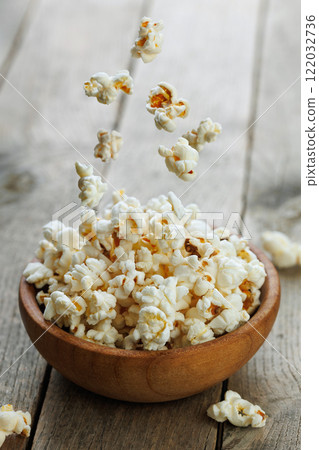 flying popcorn falling in bowl on table 122032736