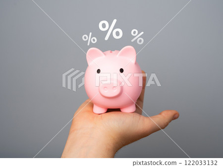 Piggy bank in hand and percent symbols. Concept of growth of savings and accumulations in a bank. Deposits and income. Save money. Pension savings. Piggy bank in hand and percent symbols. Concept of growth of savings and accumulations in a bank. Deposits and income. Save money. Pension savings. 122033132