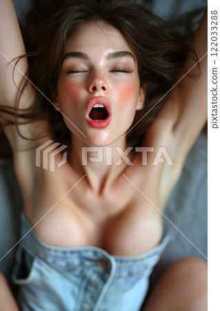 Erotic, sex, masturbation, cunnilingus, porn. Young woman having orgasm. Beautiful woman with open mouth and closed eyes enjoying sex lying in bed, top view. Sexual experience, sensual pleasure. 122033288