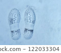 Two boot prints are visible in the snow. Concept of tracks in snow. 122033304