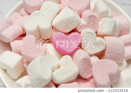 Close-up shot of heart-shaped marshmallows in a white container Close-up shot of heart-shaped marshmallows in a white container 122033558