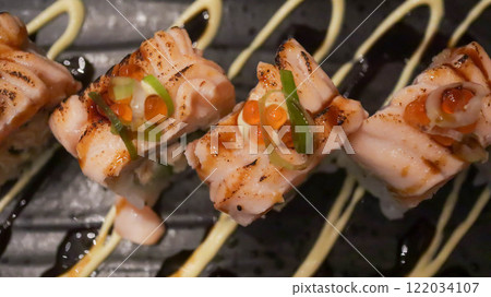 Salmon Oyako Spicy roll consist of crispy salmon skin is wrapped with sushi rice, topped with half broiled Aburi Salmon with spicy sauce 122034107