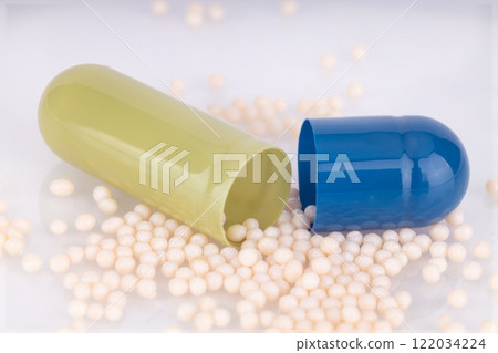 Open medical capsule with granules on surface 122034224