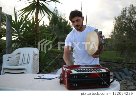 Happy Tambourine Player Performing in Fields 122034259